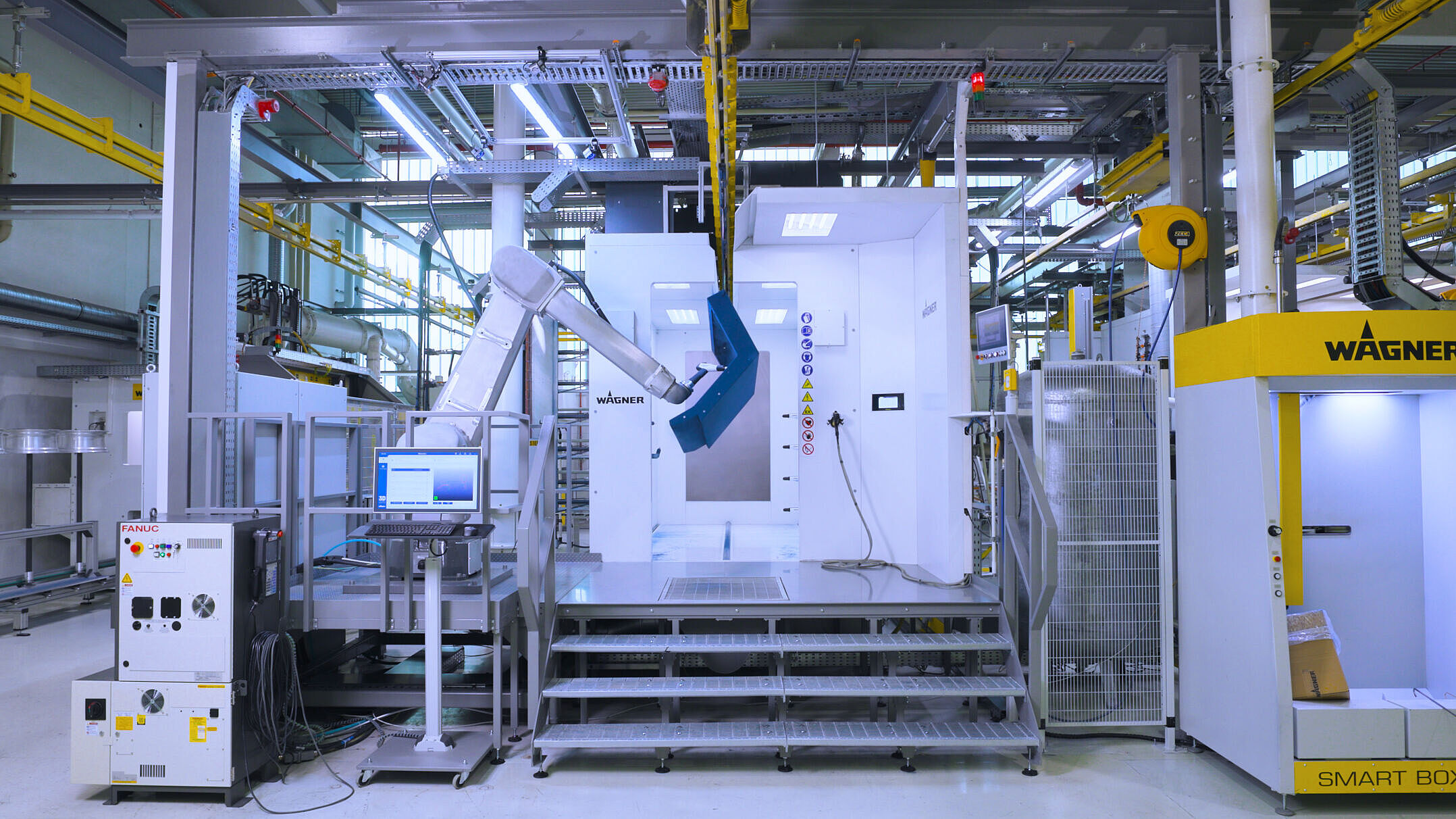 Industrieroboter beschichtet Metallteil in einer WAGNER-Beschichtungskabine.