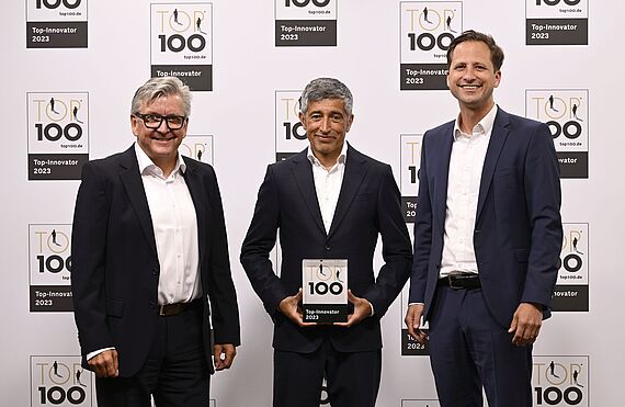 Ranga Yogeshwar (Mitte) gratuliert der J. Wagner GmbH zu ihrer Auszeichnung mit dem TOP 100-Siegel. Den Preis nehmen die Chief Technology Officers von WAGNER, Thomas Jeltsch (links) und Dr. Jens Arnoscht (rechts), entgegen.