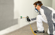 Building trade Handwerker sprüht mit ProSpray 3.25 Innenwand mit weißer Emulsion